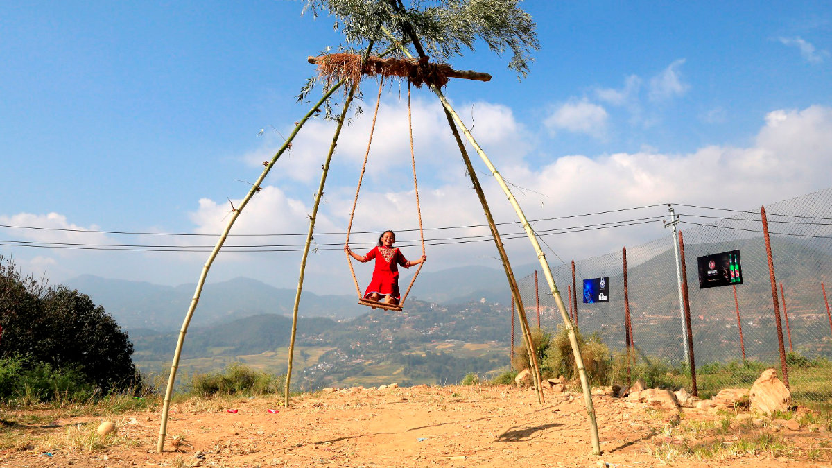 Children playing on a traditional bamboo swing (ping) during Dashain festival